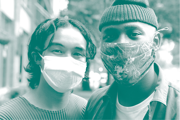 Two people wearing masks and smiling