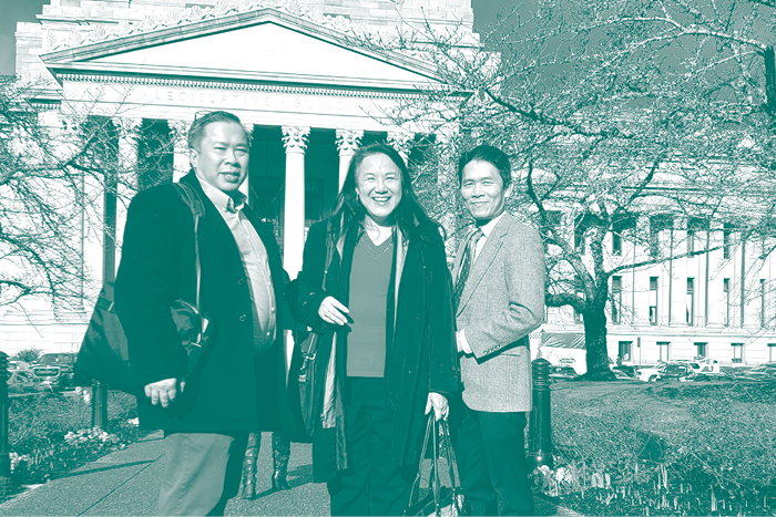Three Asian American people smile in front of the WA State Capitol Building